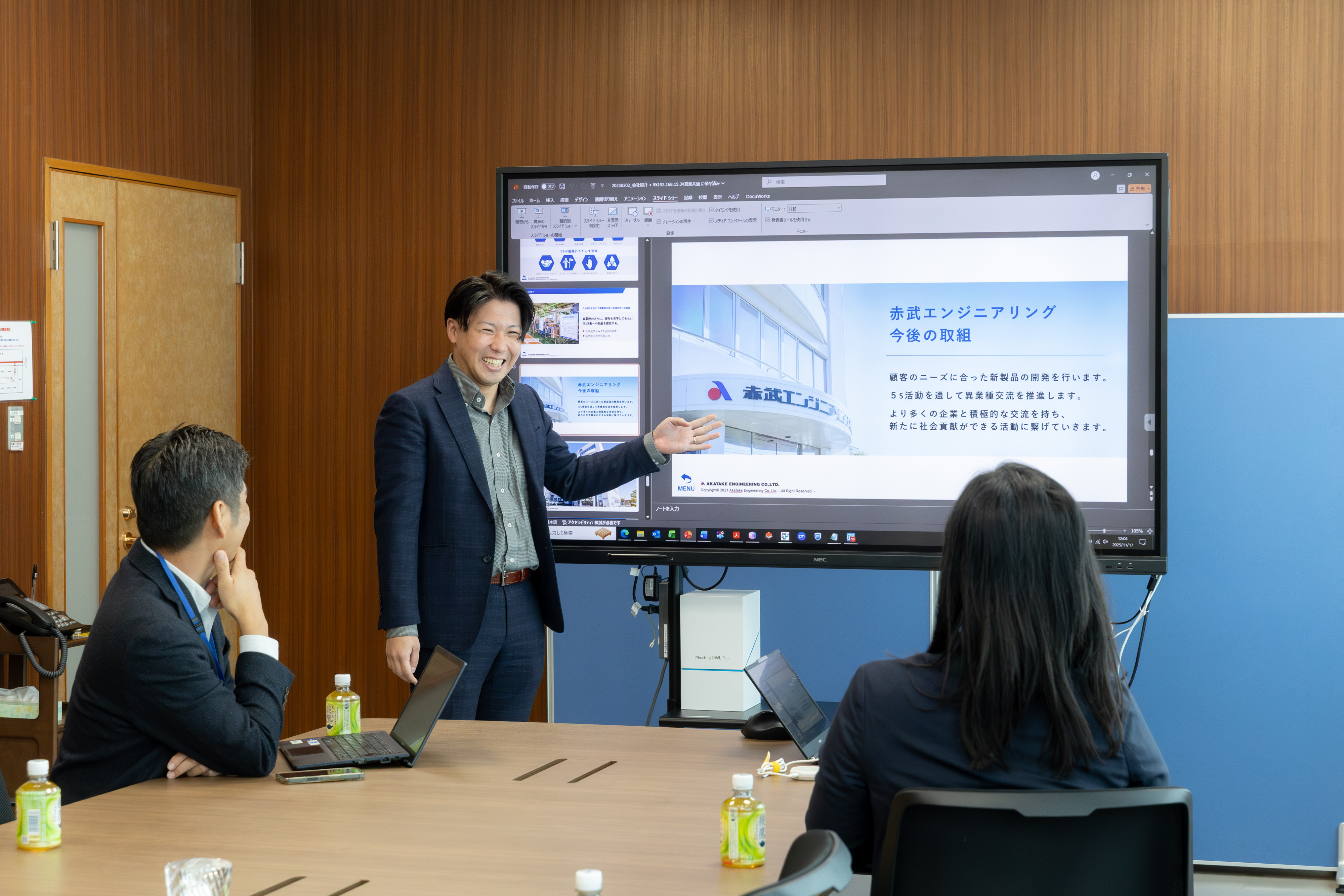 社内でプレゼンテーションを行う社員